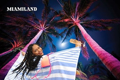 A Miami green screen photo booth participant celebrates under palm trees.